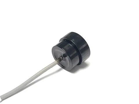Ultrasonic Material Recognition Sensor 1 with black housing, white ceramic emitting face and single grey lead wire