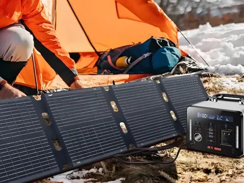 Camper unfolding a LinkitPower foldable solar panel next to a portable power station at a campsite