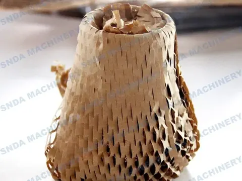 Cup-shaped sample formed from kraft honeycomb paper cushioning wrap sitting on a white surface