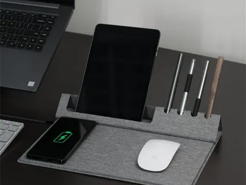 Wireless charging office mouse pad in use on a desk with a laptop