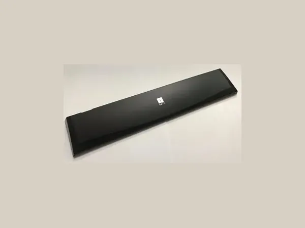 Long glossy black plastic cover with a small square printed mark — TJ-Teck