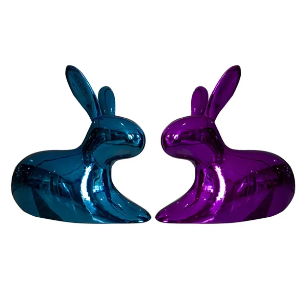 Two shiny metallic rabbit sculptures in blue and purple facing each other