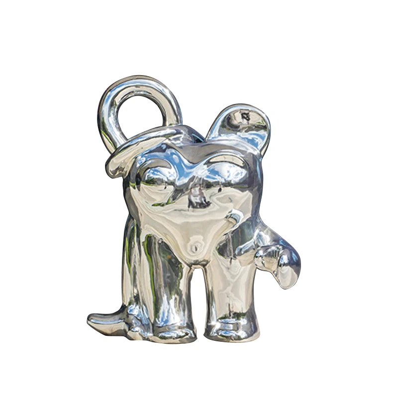 Silver metal figurine of a dog wearing a hat with a loop on top