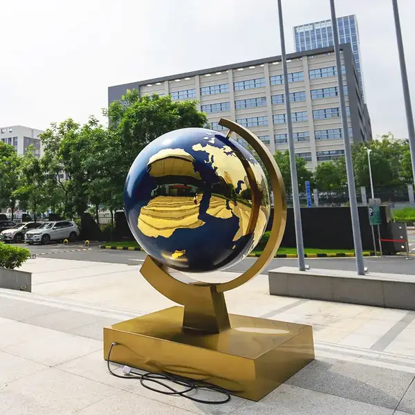 Stainless steel globe sculpture seen from the side on its trumpet shaped base