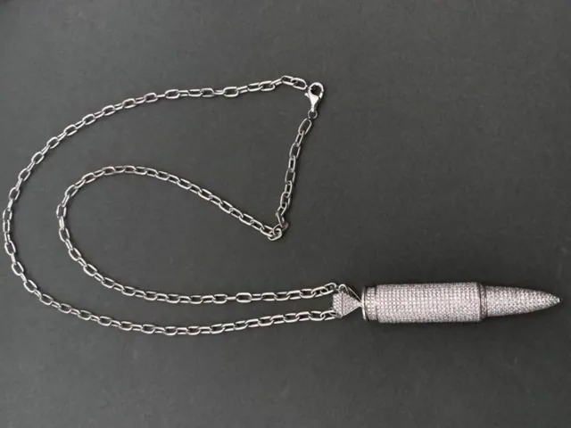 A pave diamond pendant and chain photographed in gloved hands at BH Jewelry