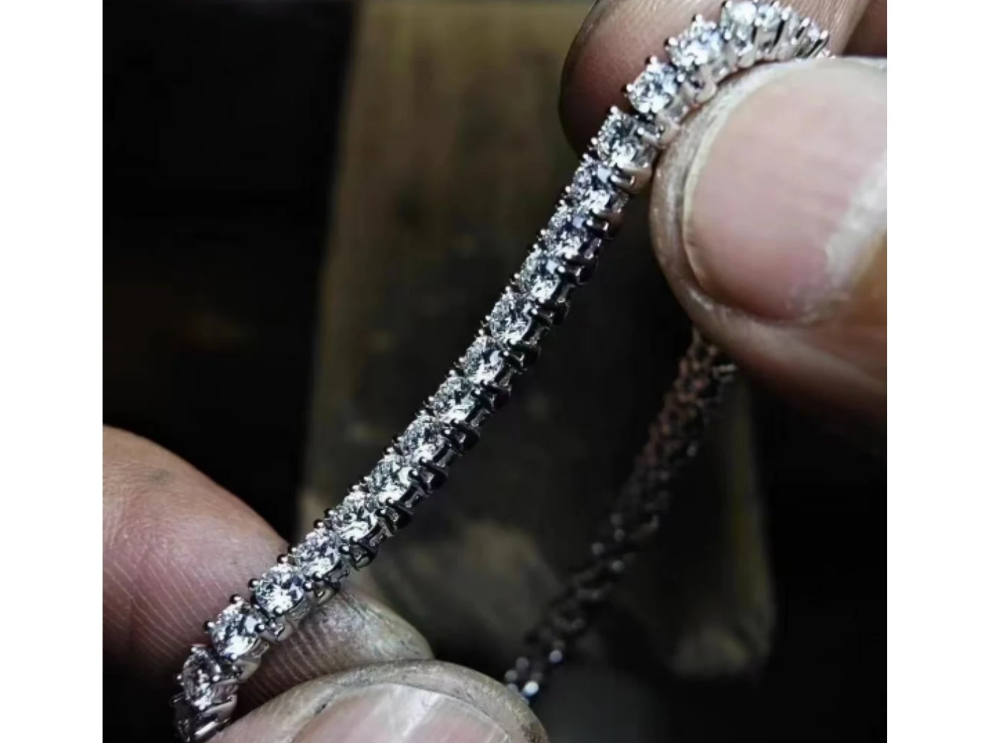 A diamond tennis bracelet laid out for inspection at the BH Jewelry bench