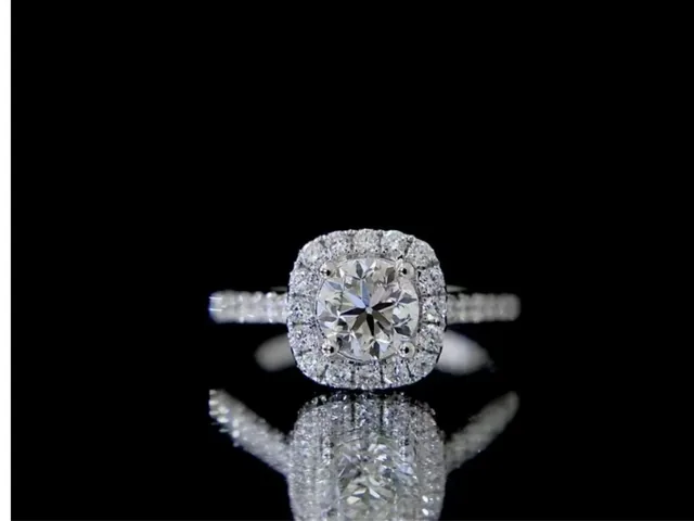 A vintage-style diamond engagement ring held in a gloved hand at BH Jewelry