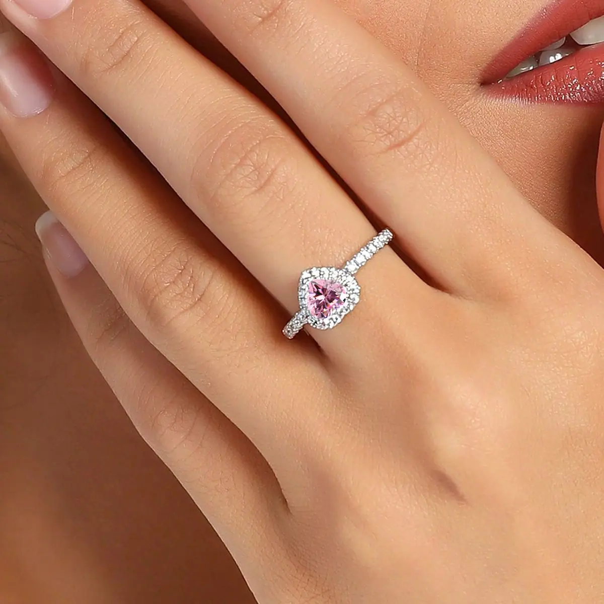 Pink halo cubic zirconia ring worn on a hand