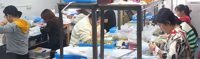 Quality inspection staff checking finished jewelry at the inspection bench