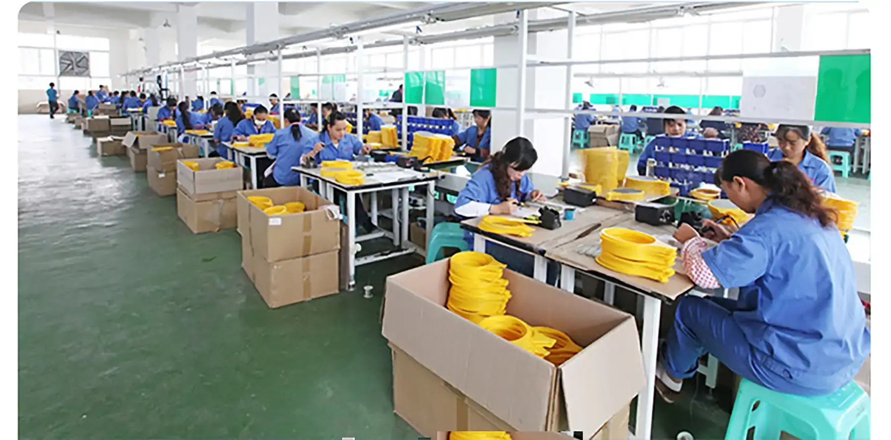 Línea de montaje de DANQ con operarios fabricando cabezales de raquetas matainsectos
