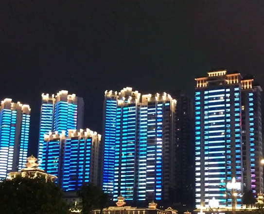 Torres residenciais gêmeas com conteúdo de fachada de mídia em cores azuis à noite