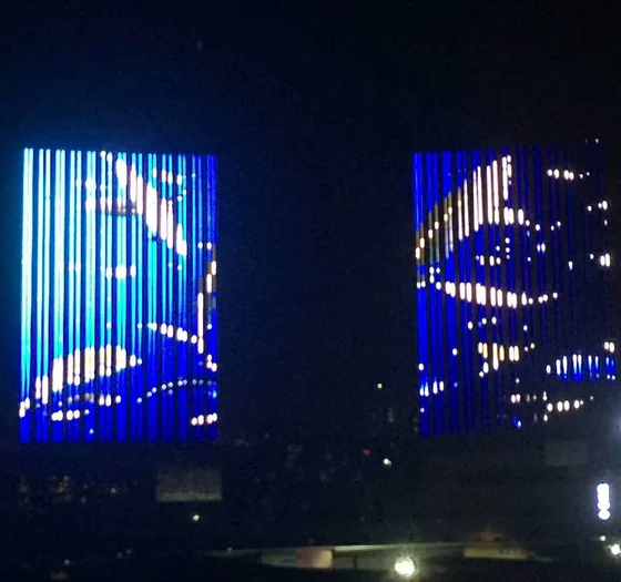 Torres de escritórios com luz linear azul vertical sincronizada em ambos os edifícios