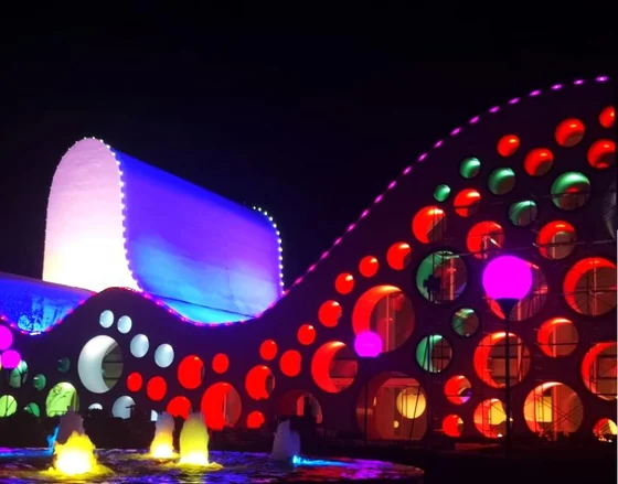 Fachada curva da galeria de arte coberta por pontos circulares de pixels de LED coloridos