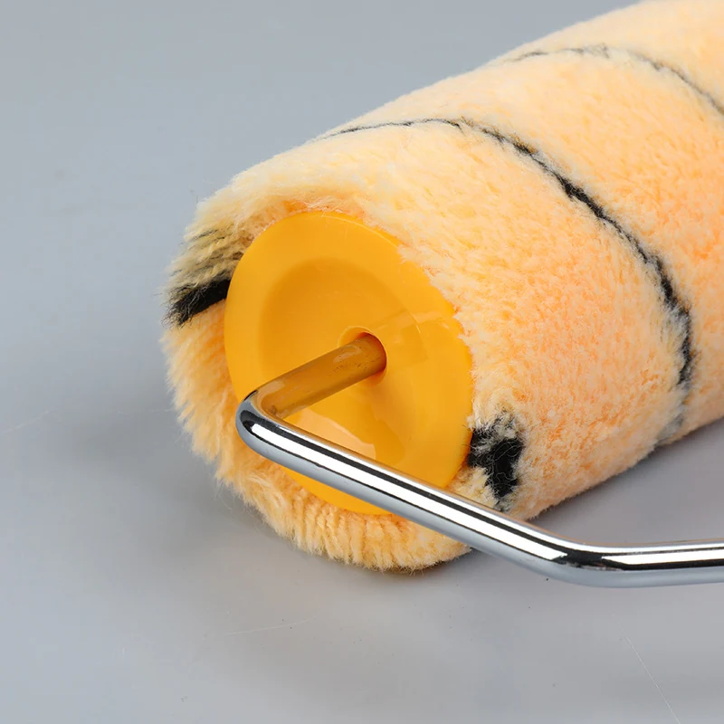 Close-up of a striped paint roller cover with yellow end cap and chrome wire frame on a plain gray background