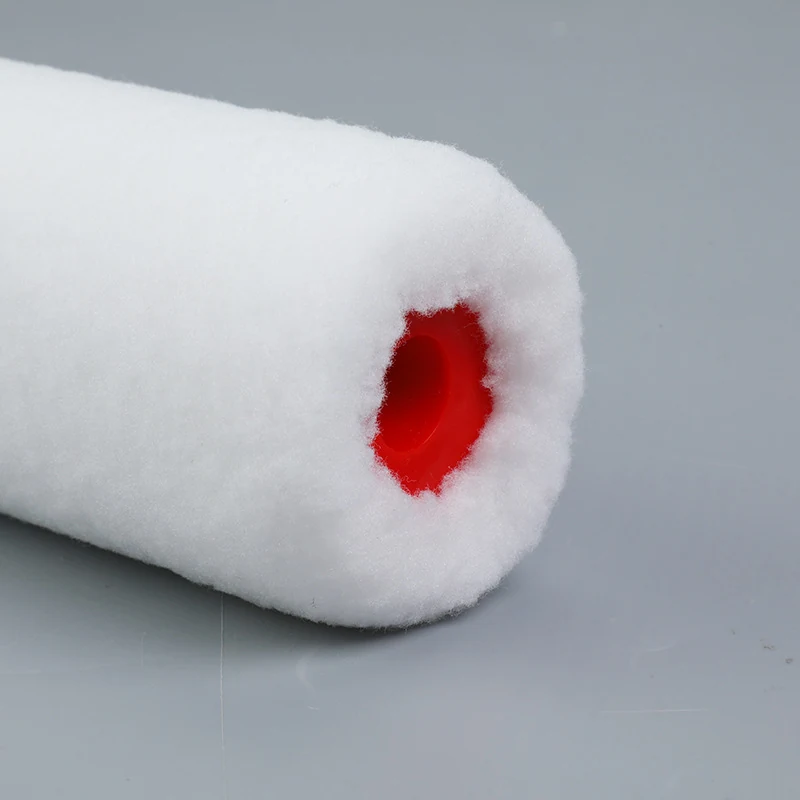 Close-up of a white fabric paint roller cover showing its red plastic core on a plain gray background