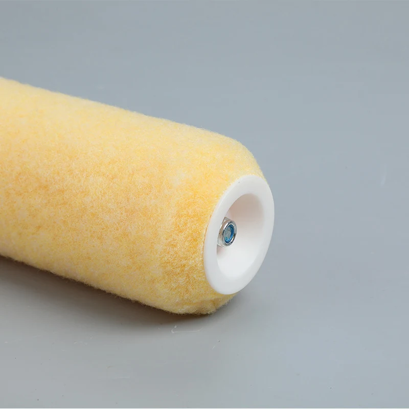 Close-up of a yellow fabric paint roller cover with white plastic end cap on a gray background