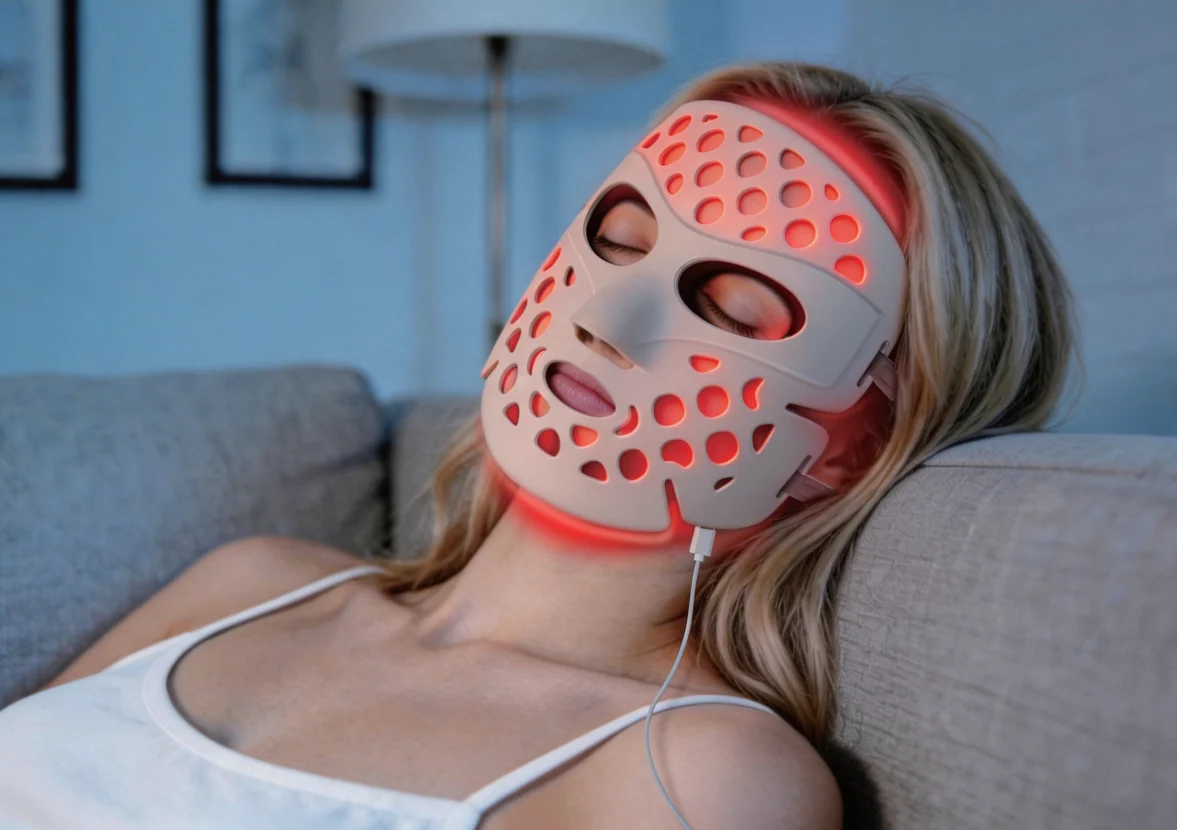 Frau entspannt sich, während sie eine LED-Lichttherapie-Gesichtsmaske trägt