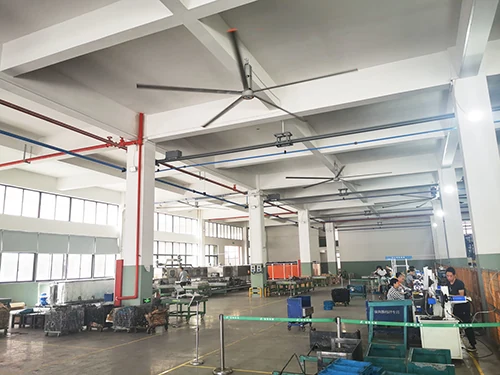 قاعة تصنيع مزودة بمراوح سقف HVLS تعمل فوق صفوف الماكينة
