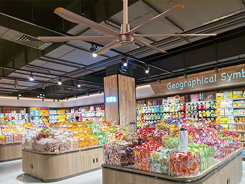 Corredor do supermercado com um grande ventilador de teto HVLS acima da vitrine de produtos hortifrutigranjeiros