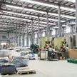 Oficina de estamparia com ventiladores de teto HVLS acima das linhas de produção