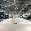 Centro de serviço de veículos com ventiladores de teto HVLS acima dos compartimentos de elevador de dois postes
