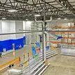 Grandes ventiladores de teto HVLS acima do piso de um armazém usados ​​para destratificação e resfriamento