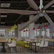 Ventilador de teto comercial HVLS acima da área de estar de uma grande cantina para funcionários