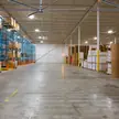 Dois ventiladores de teto HVLS acima do corredor central de um armazém de distribuição de rolos de papel