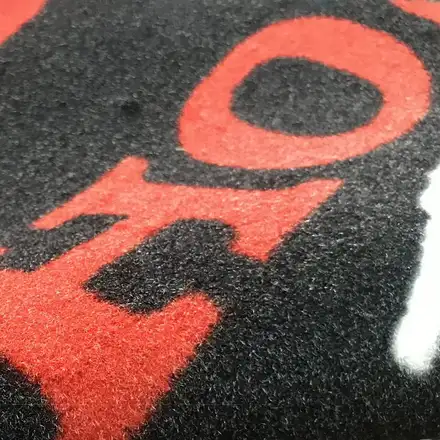 Printed advertising pit carpet laid flat showing the full design
