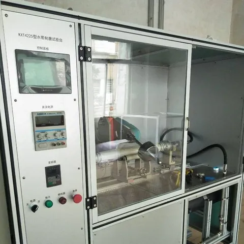 摩耗試験機。引きずりや巻き取りを受けるホースでは、カバーの摩耗が寿命を決める主な要因です。