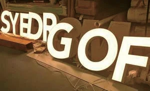 White illuminated channel letters under fabrication, lit by LED sign modules