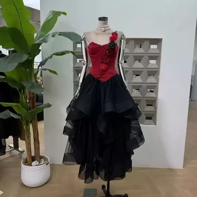 Red corset with three dimensional roses over a layered black tulle midi skirt