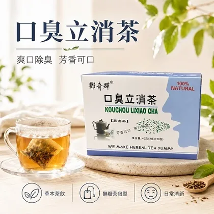 Box of Kouchou Lixiao herbal tea beside a glass cup of brewed tea with tag, on a stone coaster