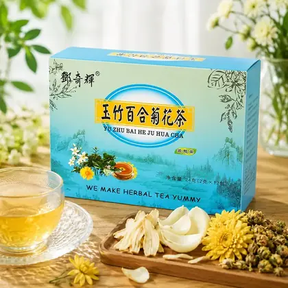 Box of chrysanthemum herbal tea beside a glass cup of brewed tea and dried herbs on a wooden table