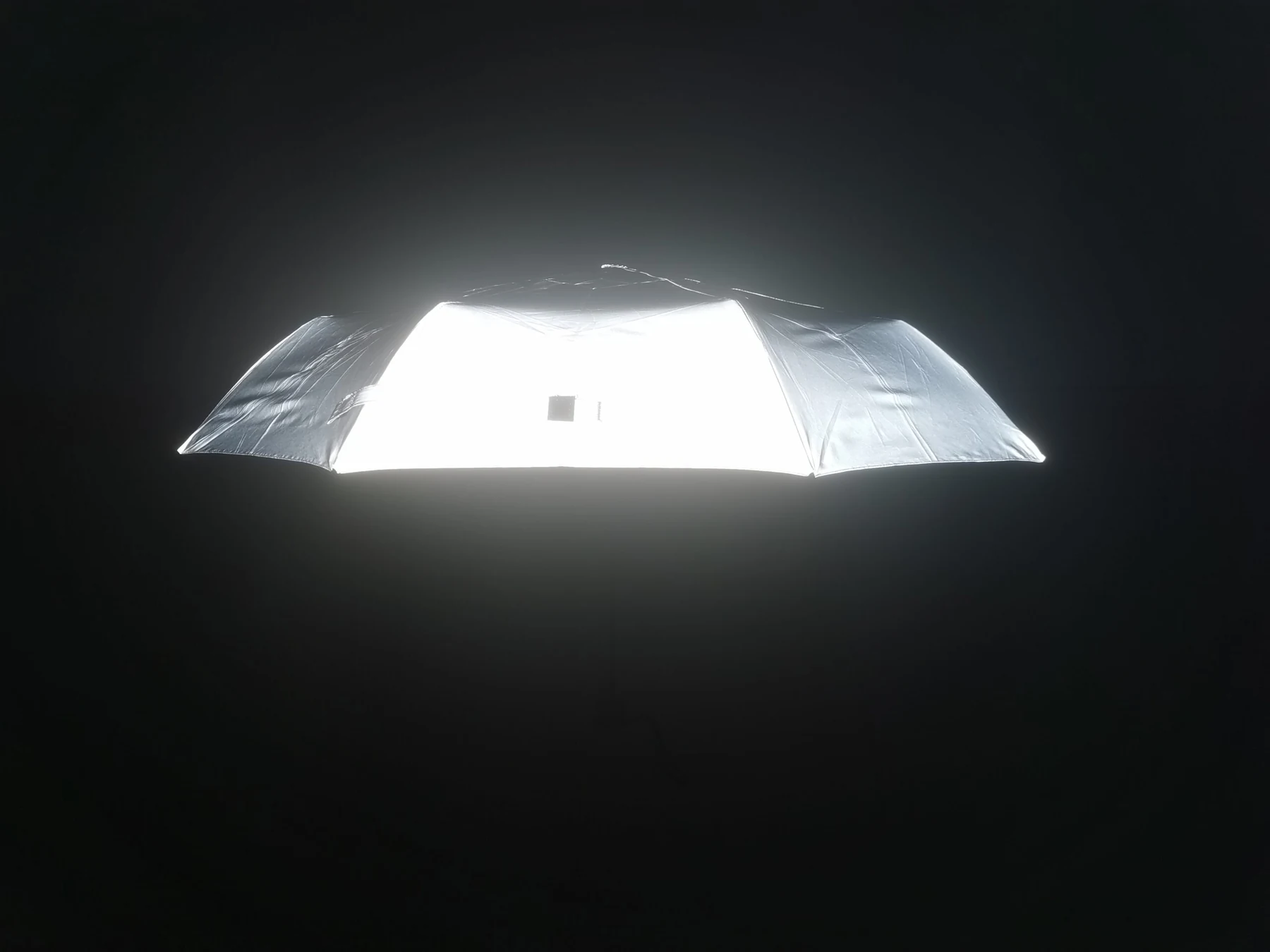 Reflektierender Schirmbezug, hell leuchtend vor dunklem Hintergrund
