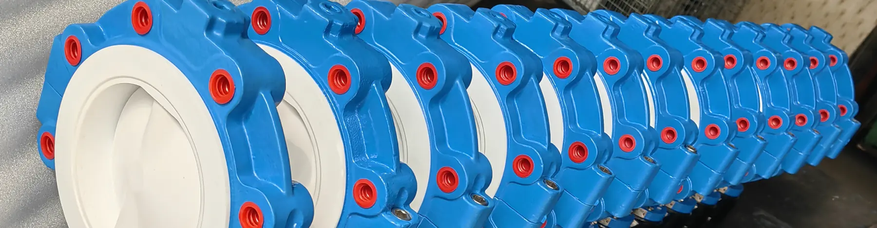Rows of PTFE lined butterfly valve bodies with red plugged bolt holes at the MIC Valve plant