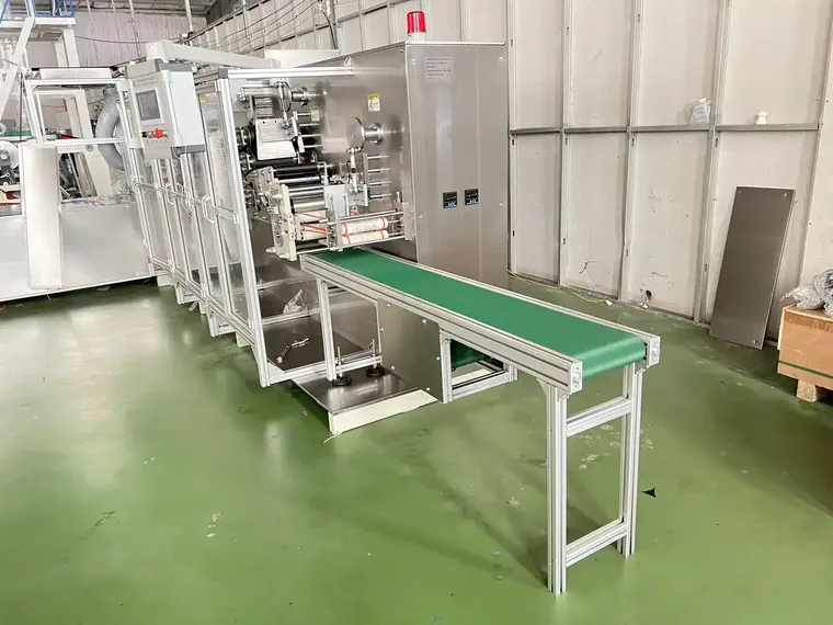 Schürzenmaschine im Werksauslauf, wobei die Servodruck- und Faltabschnitte anhand eines Kundenmusters eingestellt sind.