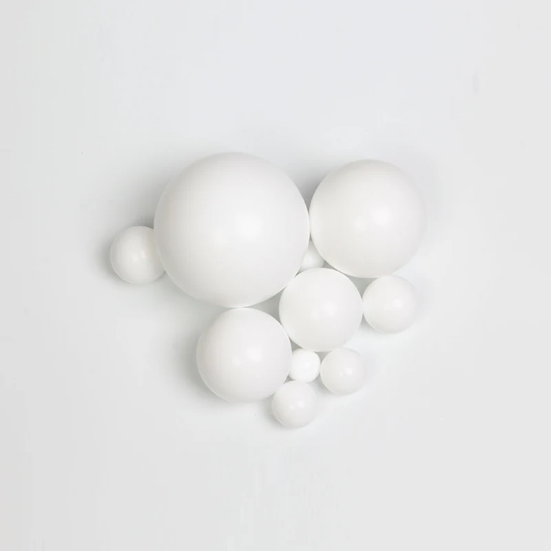 A collection of smooth white spheres of various sizes arranged on a plain white background.