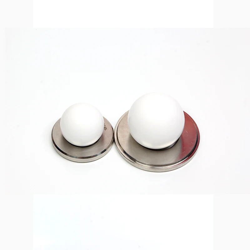 Two white spherical objects on circular metallic bases against a white background
