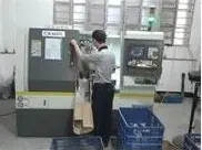 Celda de tornos CNC bajo control del operario, realizando el mecanizado secundario de piezas brutas fundidas a presión.