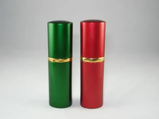 Two cylindrical metal containers, one green and one red, standing upright on a white backg
