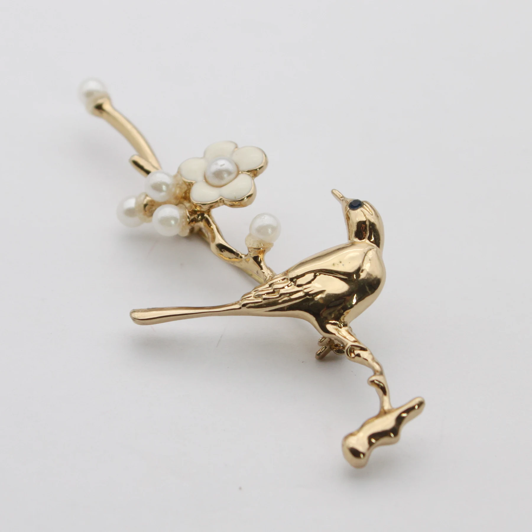Close view of the set pearls and cast branch detail on the brooch