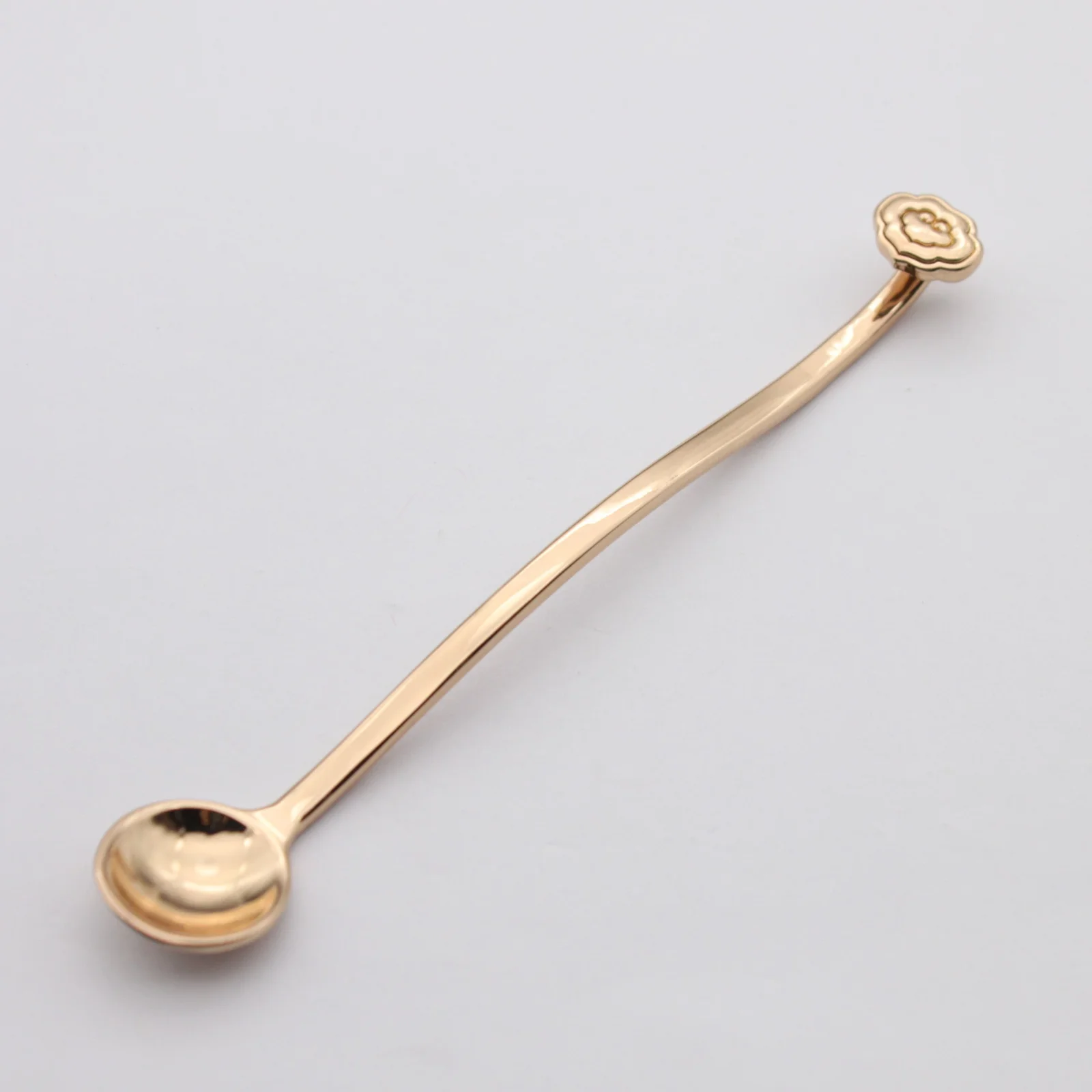 Metal cosmetic spoon shown from the side
