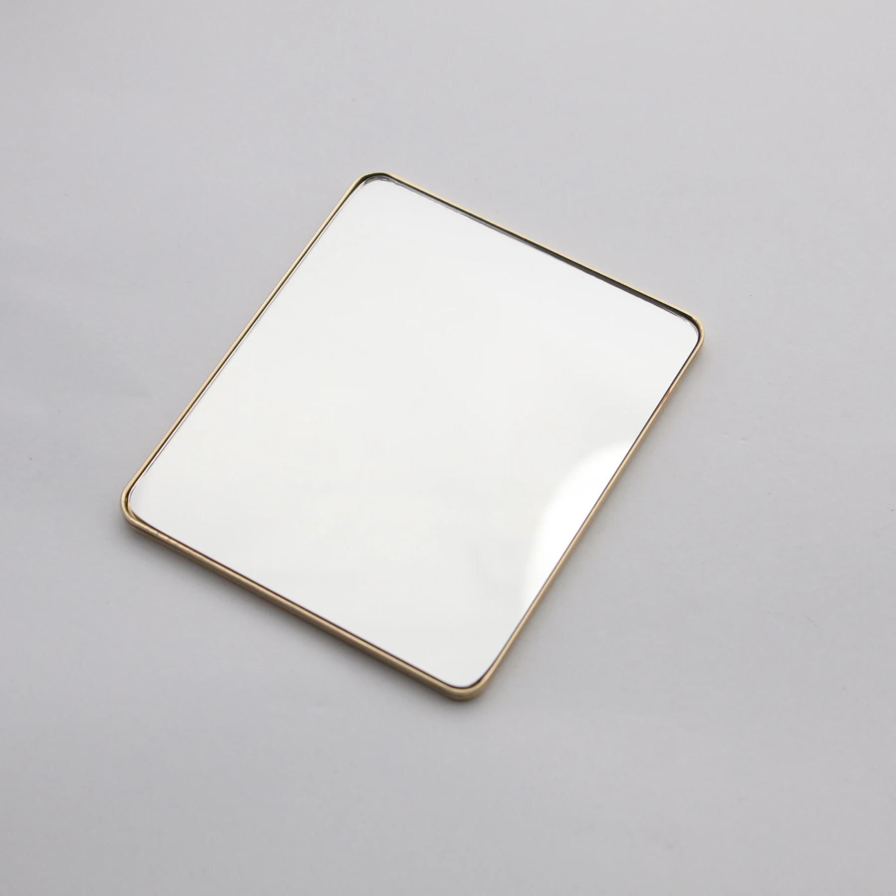 Close view of the engraved logo on the gold cosmetic mirror
