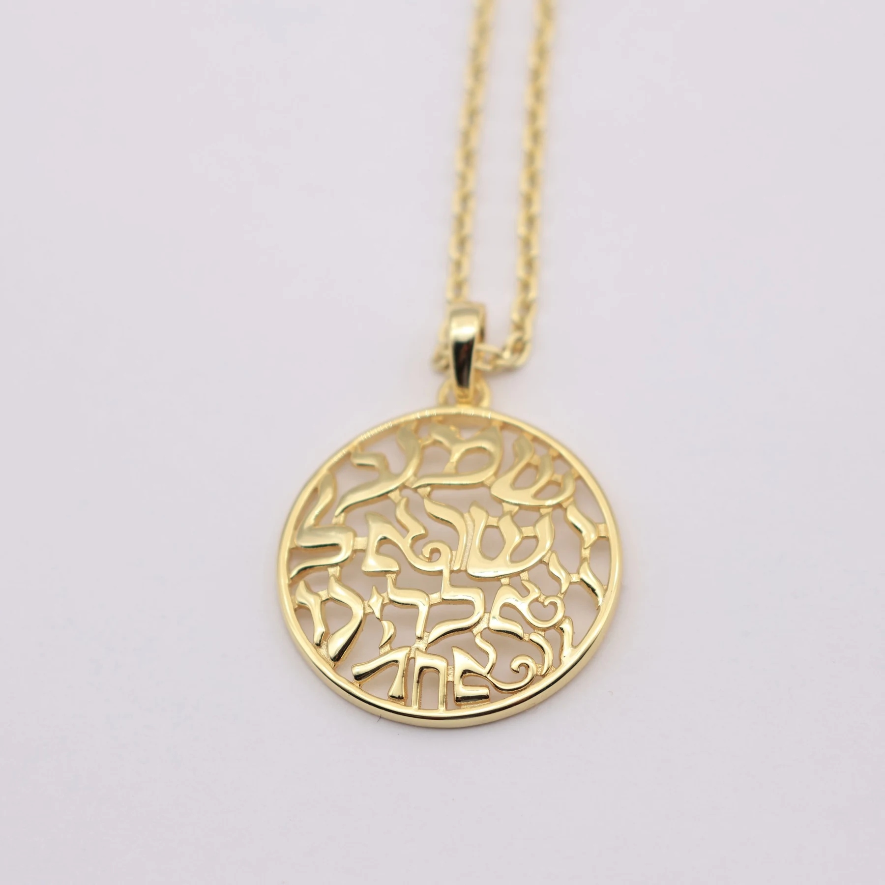 Close view of the cut out Hebrew lettering on the pendant