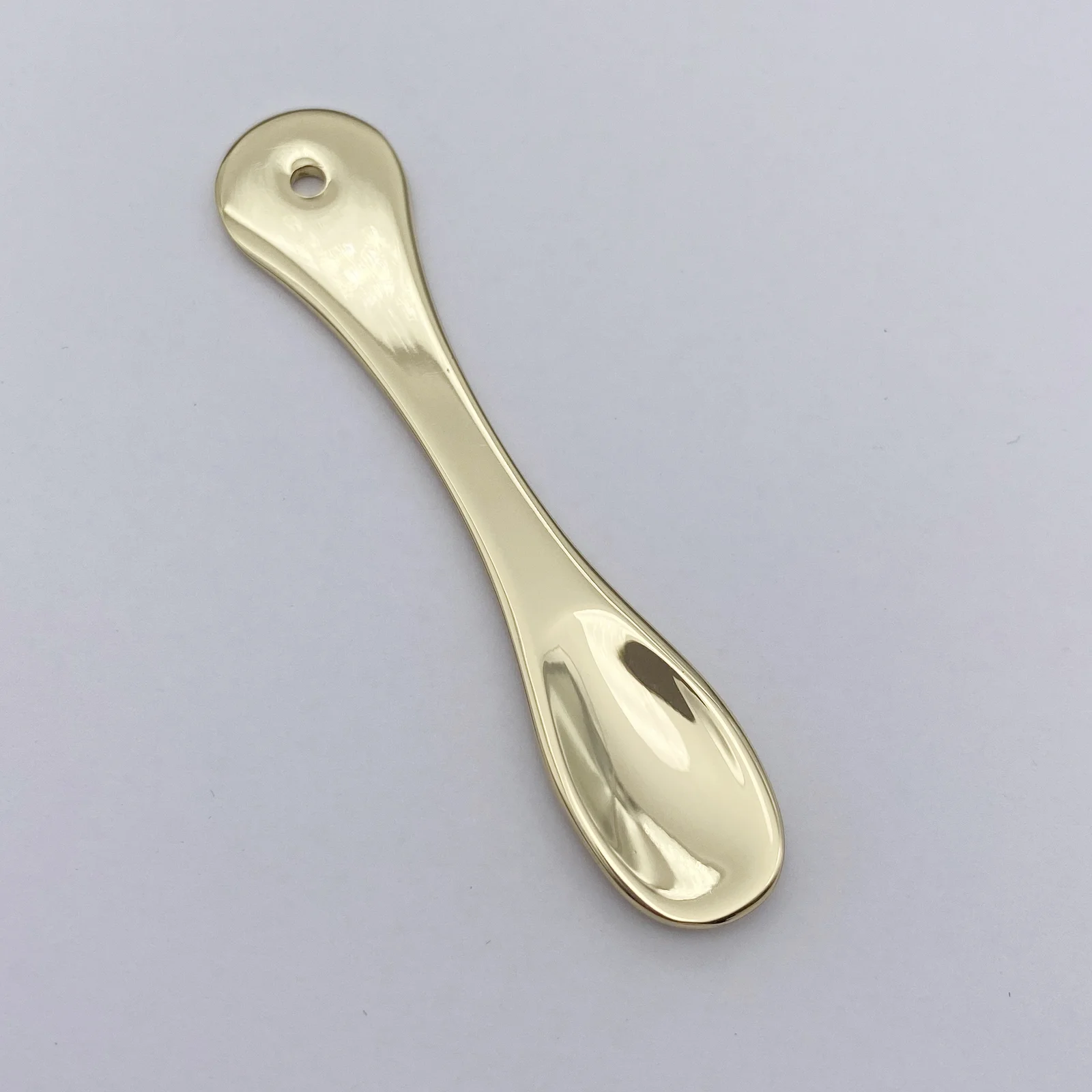 Metal cosmetic spatula shown from the side