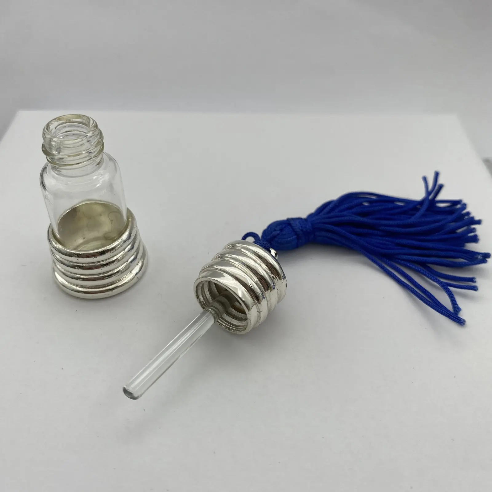 Perfume bottle keychain shown with its tassel