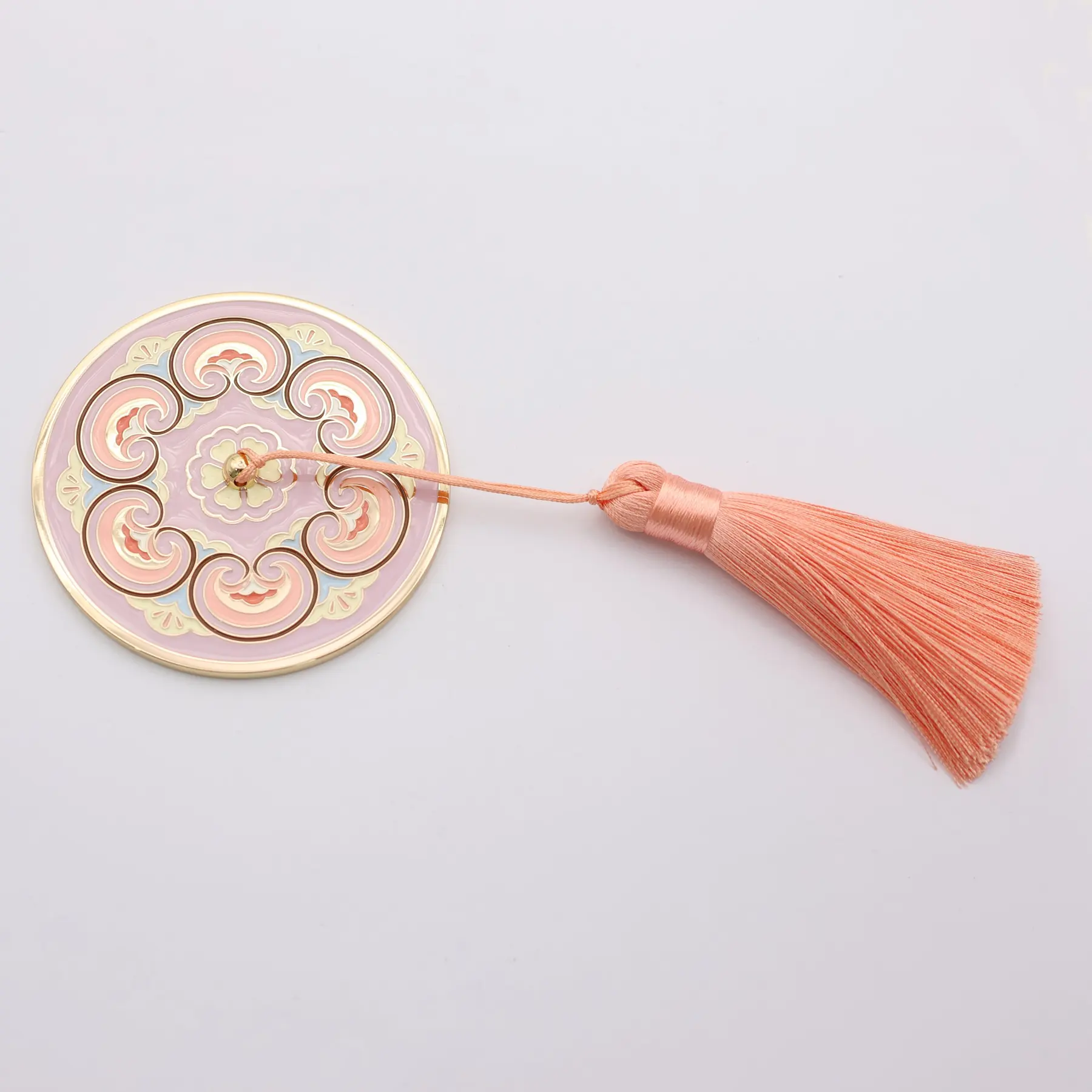 Close view of the engraved pattern and enamel on the pocket mirror