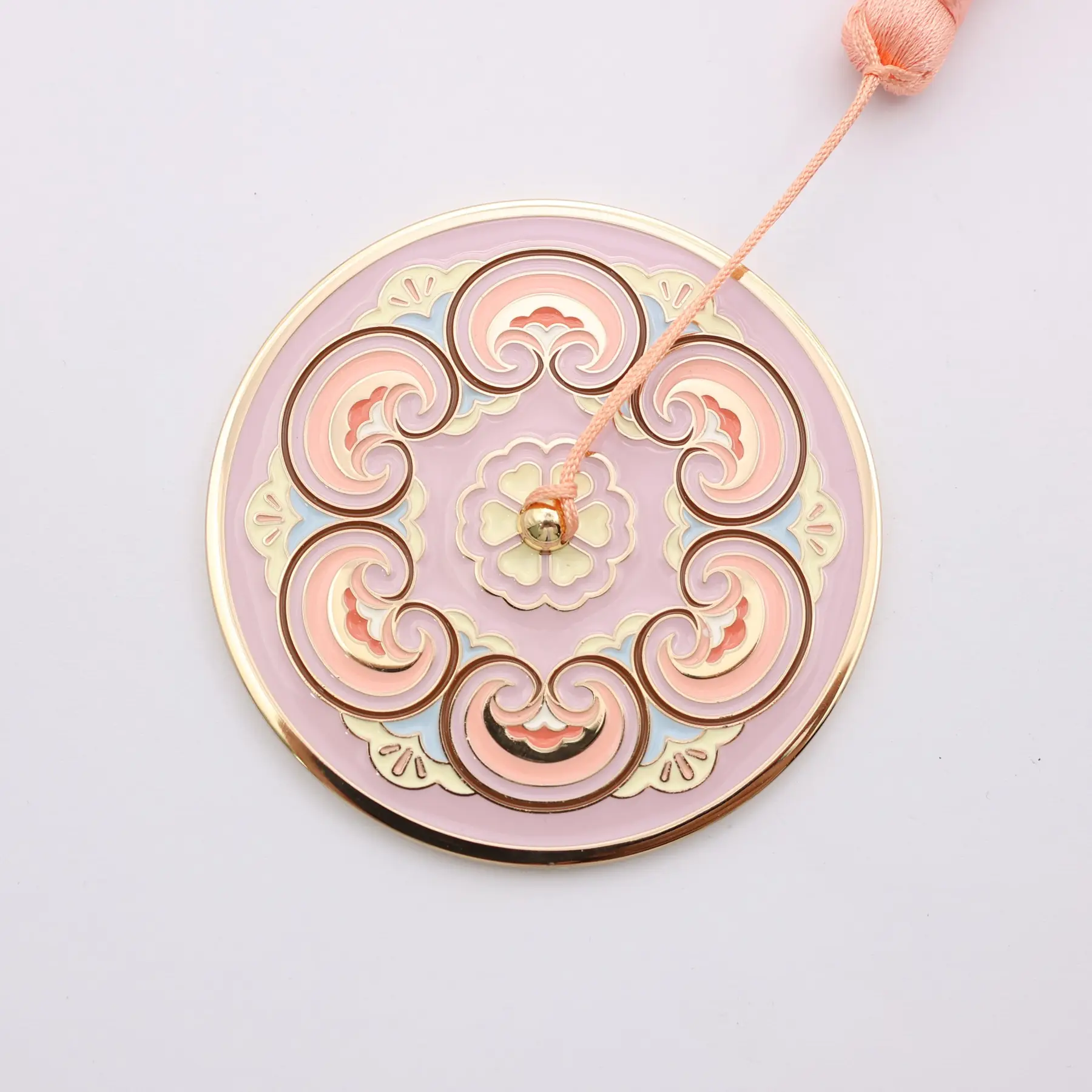Engraved pocket mirror shown with its tassel