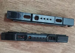 Two short black molded slider covers on a wood surface